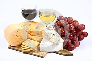 Various types of cheese, wine, grapes and crackers