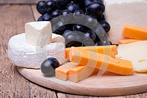 Various types of cheese on wooden background