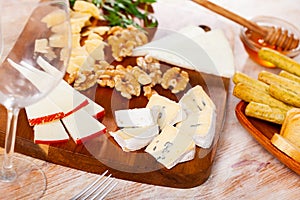 Various types of cheese on wooden board