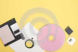 various types of disks for storing information on a yellow background, modern and retro disks and floppy disks