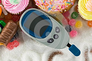 Various types of doughnuts and cupcakes with glucometer