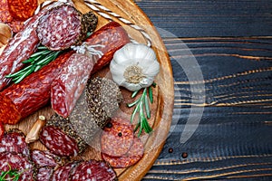 Various types of Dried organic salami sausage on wooden cutting board