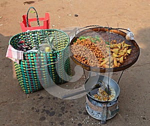 Various types of fritters snack mixed with curry leaves on rattan tray