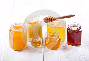 Various types of honey in glass jars photo