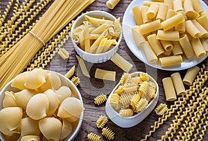 Various types of pasta on the wooden background