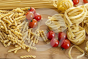 Various types of raw Italian wheat flour pasta with cherry tomatoes