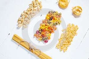 Various uncooked pasta on white background.