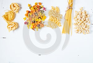 Various uncooked pasta on white background. Top view.