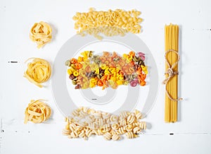 Various uncooked pasta on white background. Top view.