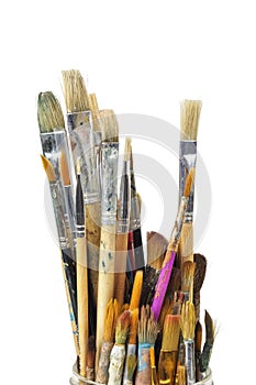 Various used paint brushes on a white background