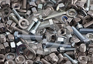 Various, various bolts, nuts, screws and washers lying all together in a heap, top view