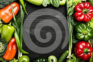 Various vegetables arranged on black wooden table. Space for writing