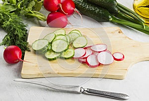Various vegetables: garden radish, cucumbers, onions on a white