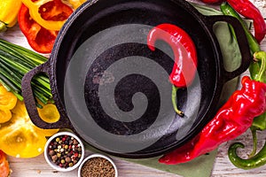 Various vegetables ingredients on wooden table around frying pan