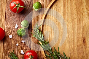 Various vegetables, seasoning and spicies around blank plate on rustic wooden background, top view