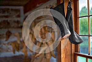 Various vintage boots suspended in an old workshop. old way of making shoes