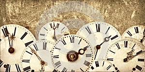 Various vintage clock faces in front of an old wall