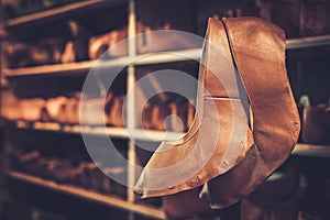 Various of vintage wooden shoe lasts in a row on the shelves.