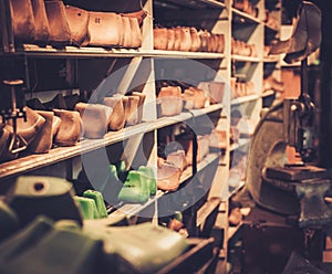 Various of vintage wooden shoe lasts in a row on the shelves.
