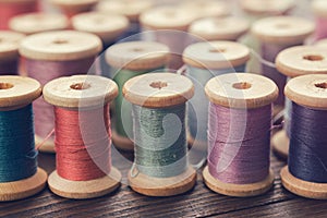 Various vintage wooden spools of multicolored threads