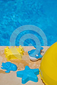 Various water toys on the side of a swimming pool