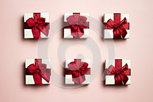 A various white gift boxes with red ribbon over the pink background.