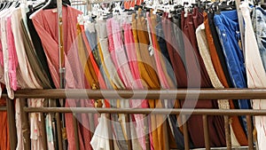 Various women`s clothes hanging in row on hangers in a clothing store