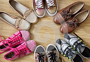 Various women`s shoes and sneakers stand in the form of a circle with a free space in the middle