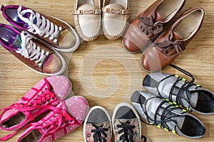 Various women`s shoes and sneakers stand in the form of a circle with a free space in the middle