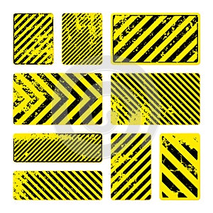 Various yellow grunge warning signs with diagonal lines. Old attention, danger or caution sign, construction site