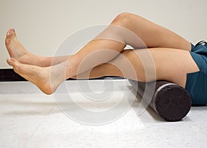 Varsity athlete using a foam roller to release her tight muscles
