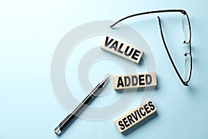 VAS - Value Added Services text on the wooden block ,blue background