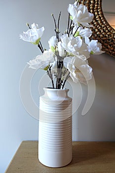 Vase of artificial flowers on side table