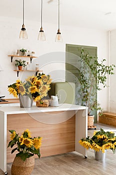 Vase with beautiful yellow sunflowers in the kitchen