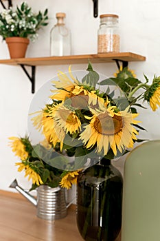Vase with beautiful yellow sunflowers in the kitchen