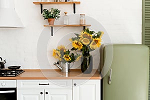 Vase with beautiful yellow sunflowers in the kitchen