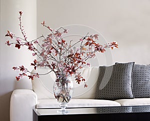 Vase of blossoms on table in modern living room