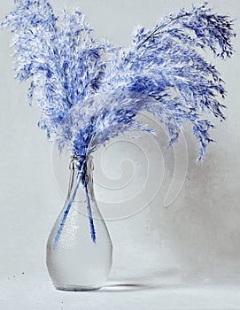 Vase of blue reeds on grunge gray background with copy space