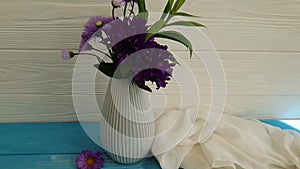 Vase of chrysanthemums on a wooden background slow motion