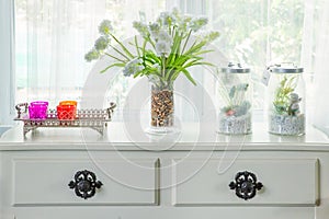 Vase with flower and vintage decorate on table with windowsill i