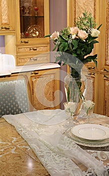 Vase with flowers on a table on a wooden kitchen background