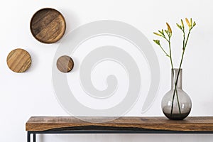 Vase with flowers on the wooden console table.