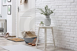 Vase with fresh eucalyptus branches on table in entryway. Interior design