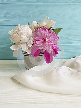 Vase of a peony blossom bouquet greeting soft on a colored anniversary wooden background