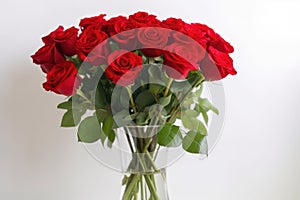 a vase of red roses against a white background