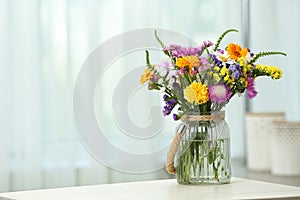 Vase with wild flowers on table