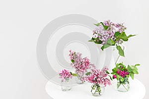 Vases with blooming spring flowers on a round table