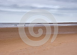 Vast beach and horizon with figures, Norfolk, UK photo