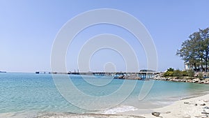 The vast blue sky and sea with a long bridge