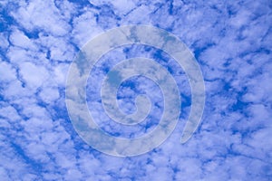 The vast blue sky with small panoramic clouds.